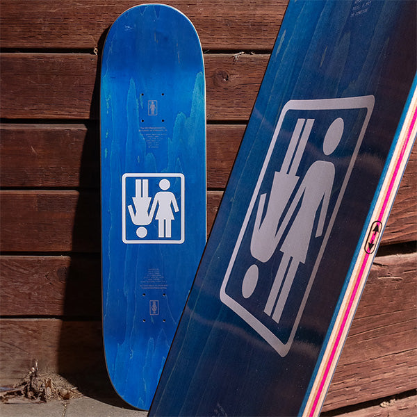 Two twin tip skateboards sitting up against a wall