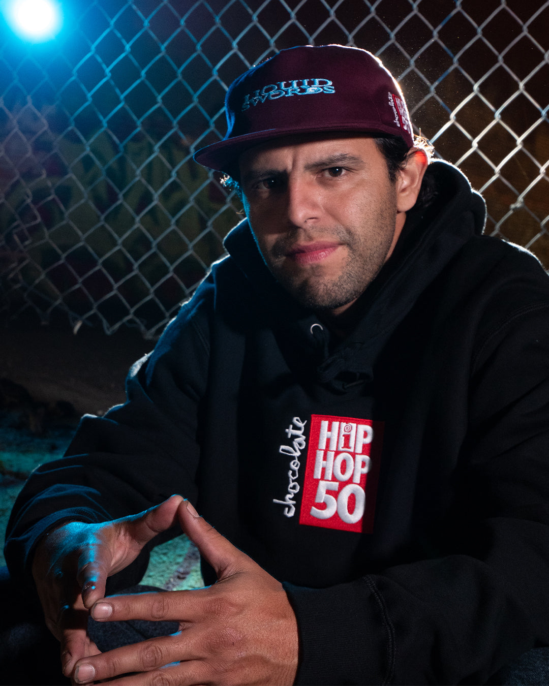 Alvarez portrait near a fence with a skateboard