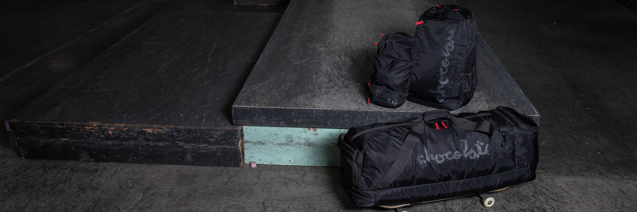 Two black bags with visible branding on a concrete surface.