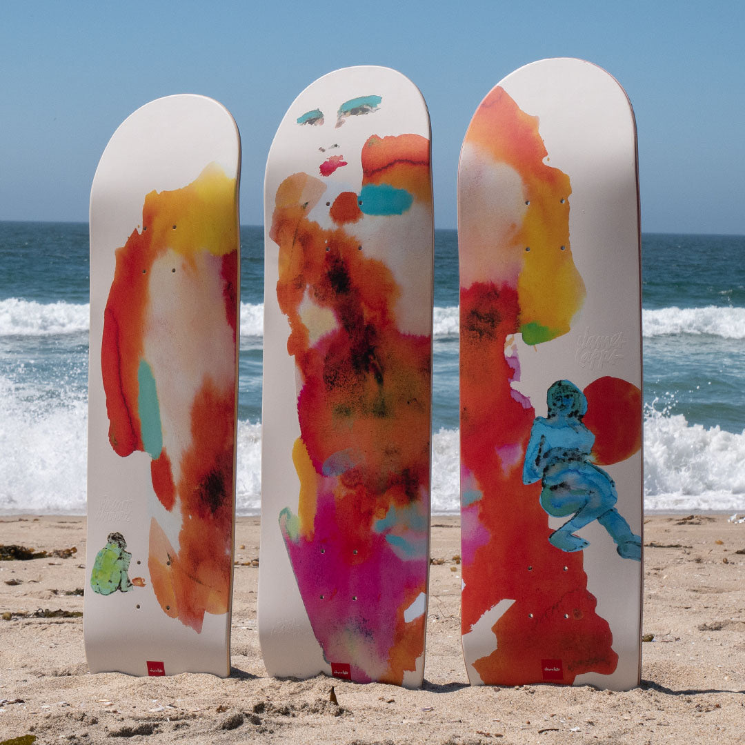 3 Skateboards sticking out of the sand on the beach