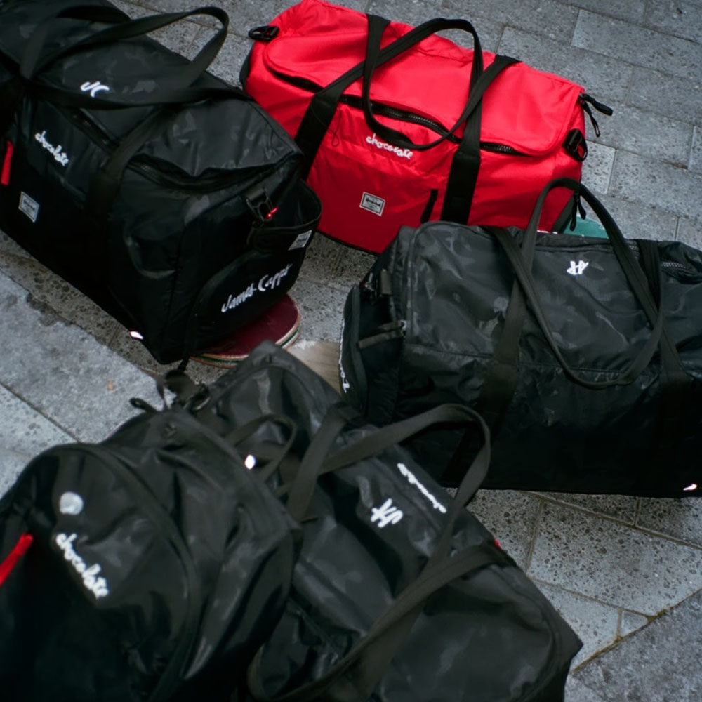 A bunch of Herschel bags chillin on some skateboards